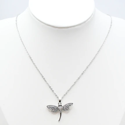 Collier argenté femme à pendentif libellule aux ailes ajourées serties de strass, sur buste blanc