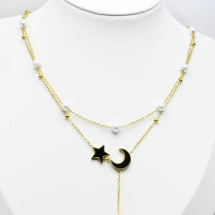 Collier double rang doré sur buste blanc, détail de l'étoile et du croissant de lune noirs