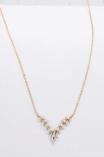 Collier chaîne fine dorée à guirlande de petites feuilles brillantes en V, vue d'ensemble à plat