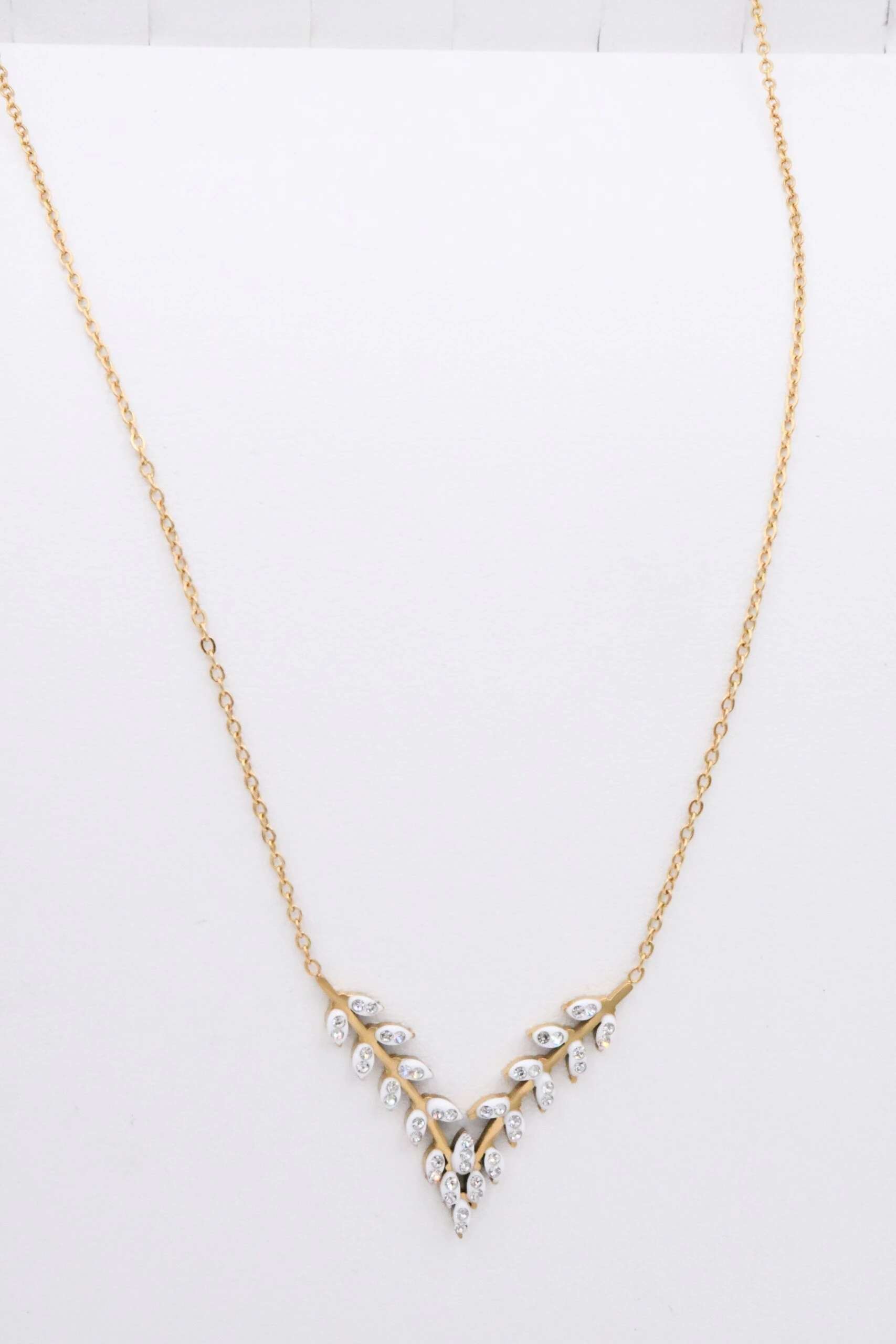 Collier chaîne fine dorée à guirlande de petites feuilles brillantes en V, vue d'ensemble à plat