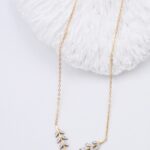Collier doré femme motif feuillage et détails brillants