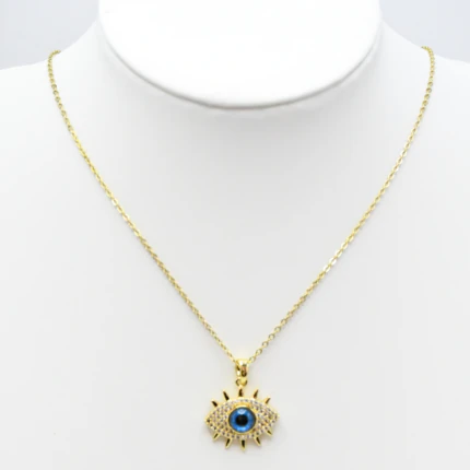 Collier chaîne fine dorée à pendentif œil protecteur bleu et strass présenté sur un buste blanc