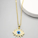 Collier doré femme à pendentif mauvais œil bleu pavé de strass et cils dorés, vue rapprochée