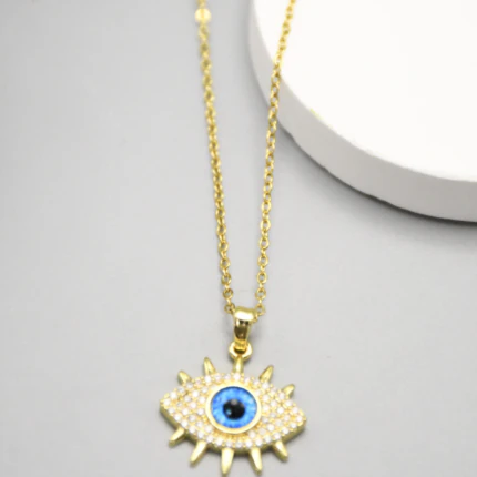 Collier doré femme à pendentif mauvais œil bleu pavé de strass et cils dorés, vue rapprochée