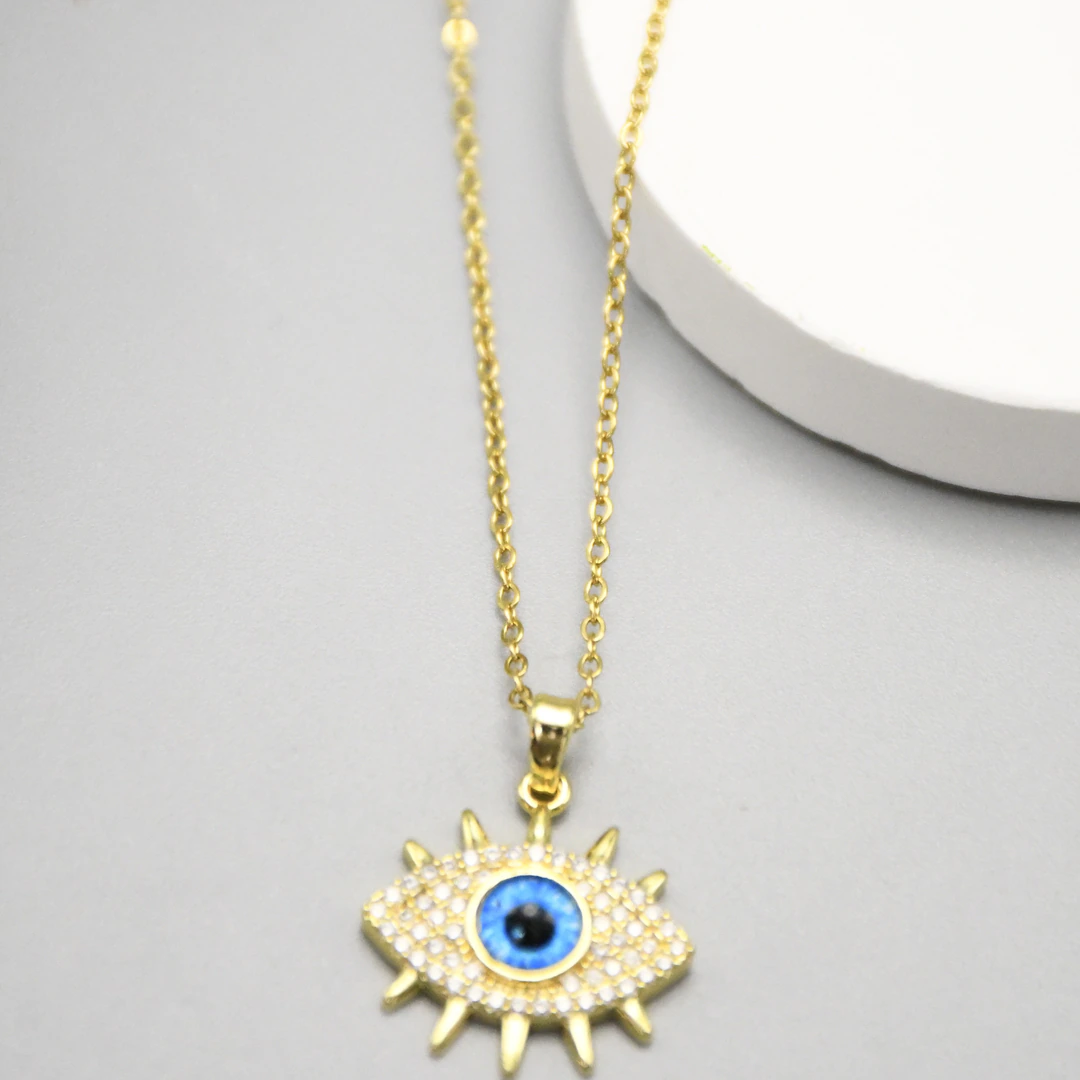 Collier doré femme à pendentif mauvais œil bleu pavé de strass et cils dorés, vue rapprochée