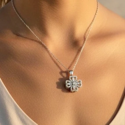 Collier argenté femme à pendentif trèfle à quatre feuilles ajouré serti de strass, porté au cou