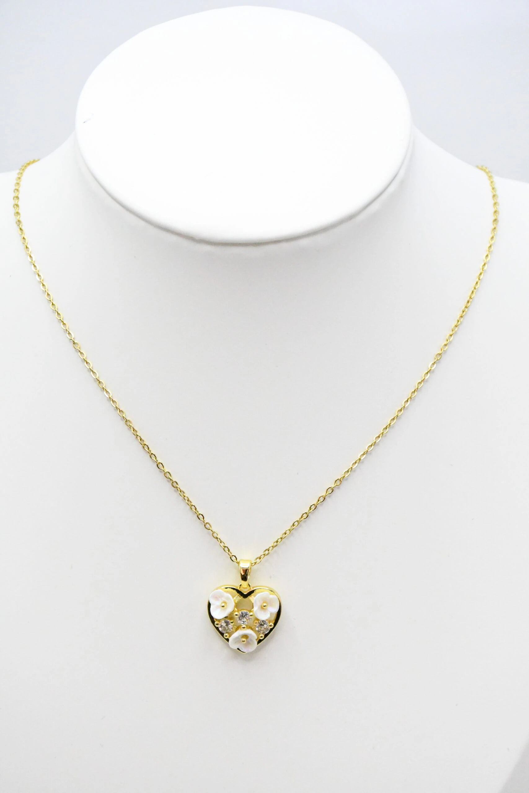 LV-CL-55 Collier doré femme à pendentif cœur orné de petites fleurs blanches en relief, présenté sur un buste