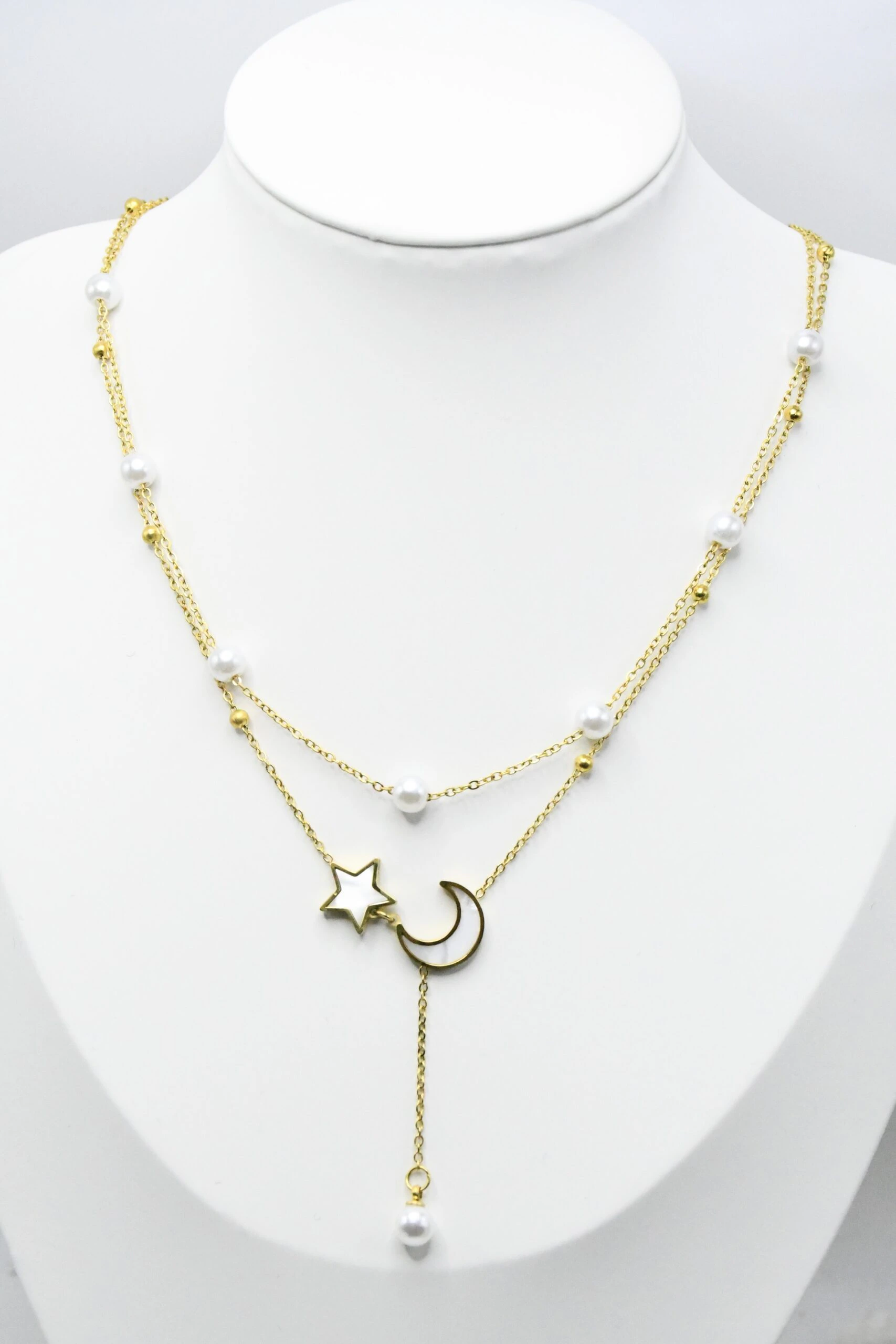 Collier double rang doré sur buste, vue d'ensemble des chaînes perlées et de la chute à perle blanche