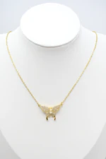 Collier doré femme à pendentif papillon pavé de strass et petites perles blanches, sur buste blanc