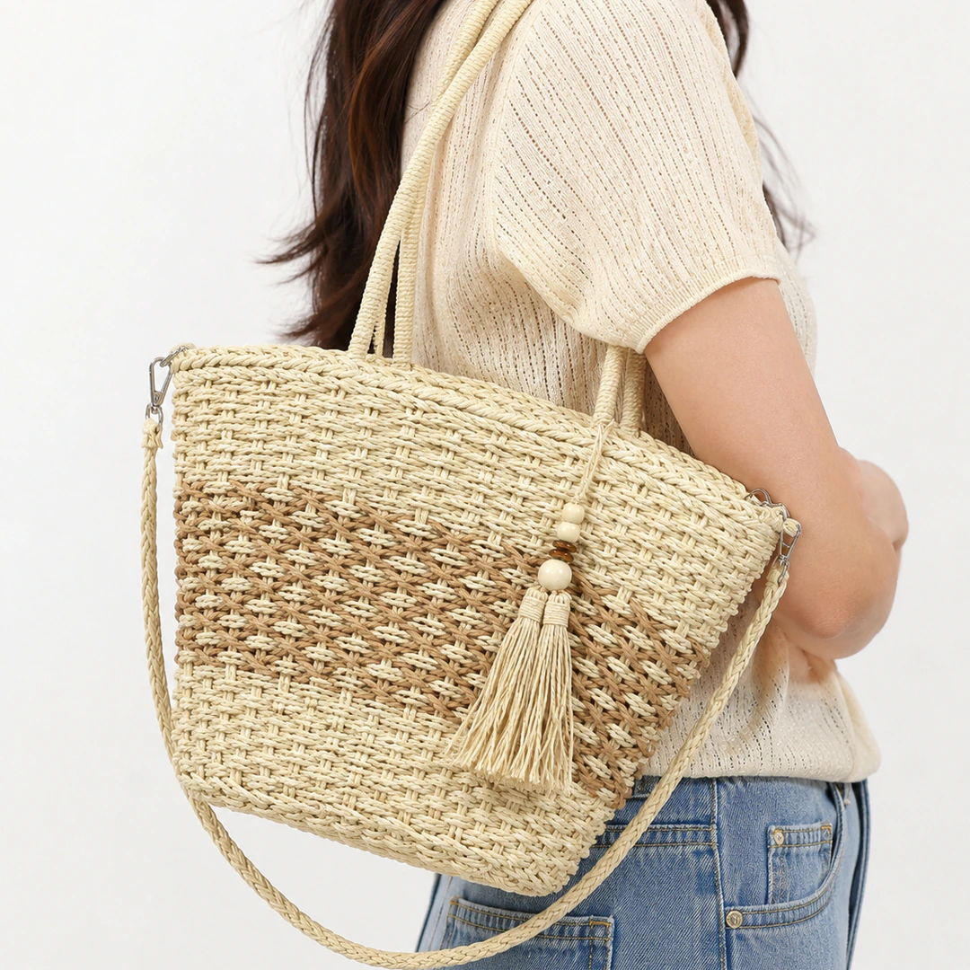 Sac panier femme beige et camel effet tressé avec pompon frangé à perles porté à l'épaule
