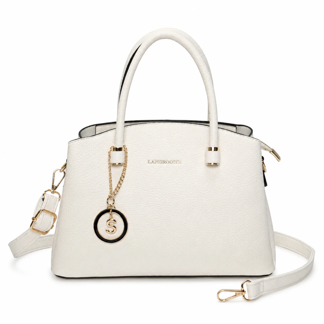 Sac à main blanc vu de face avec bandoulière accrochée et médaillon doré cerclé de noir