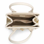 Sac à main beige ouvert vu de dessus : doublure taupe, compartiments et poches zippées