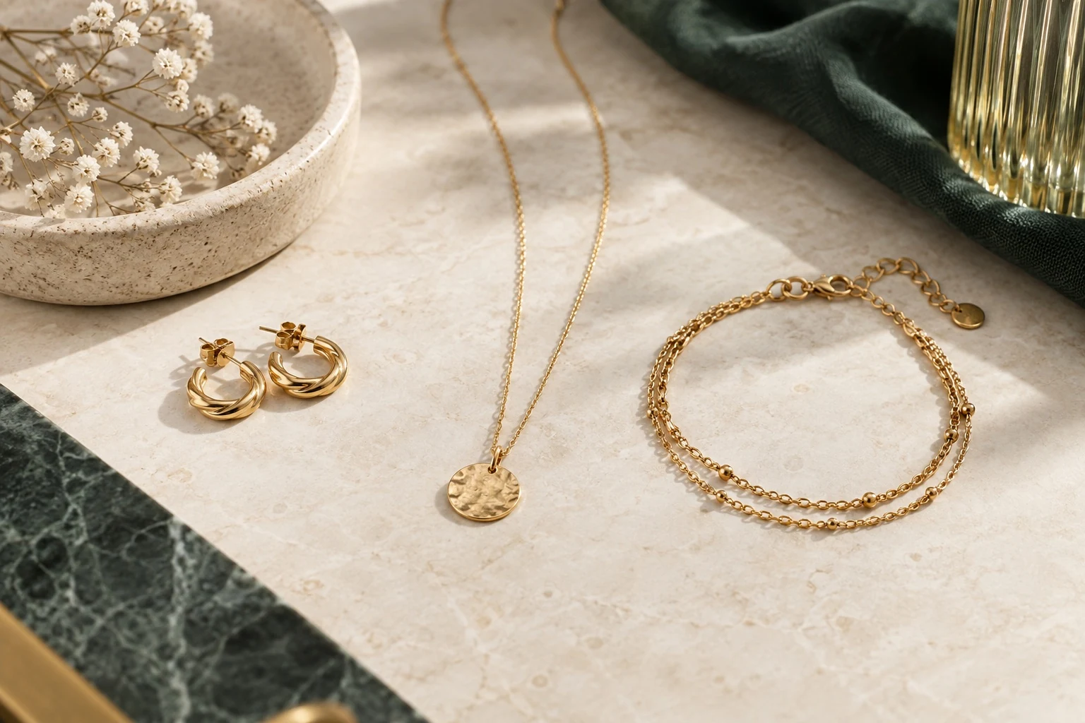 Collier, bracelet et boucles dorés illustrant les bijoux en acier inoxydable